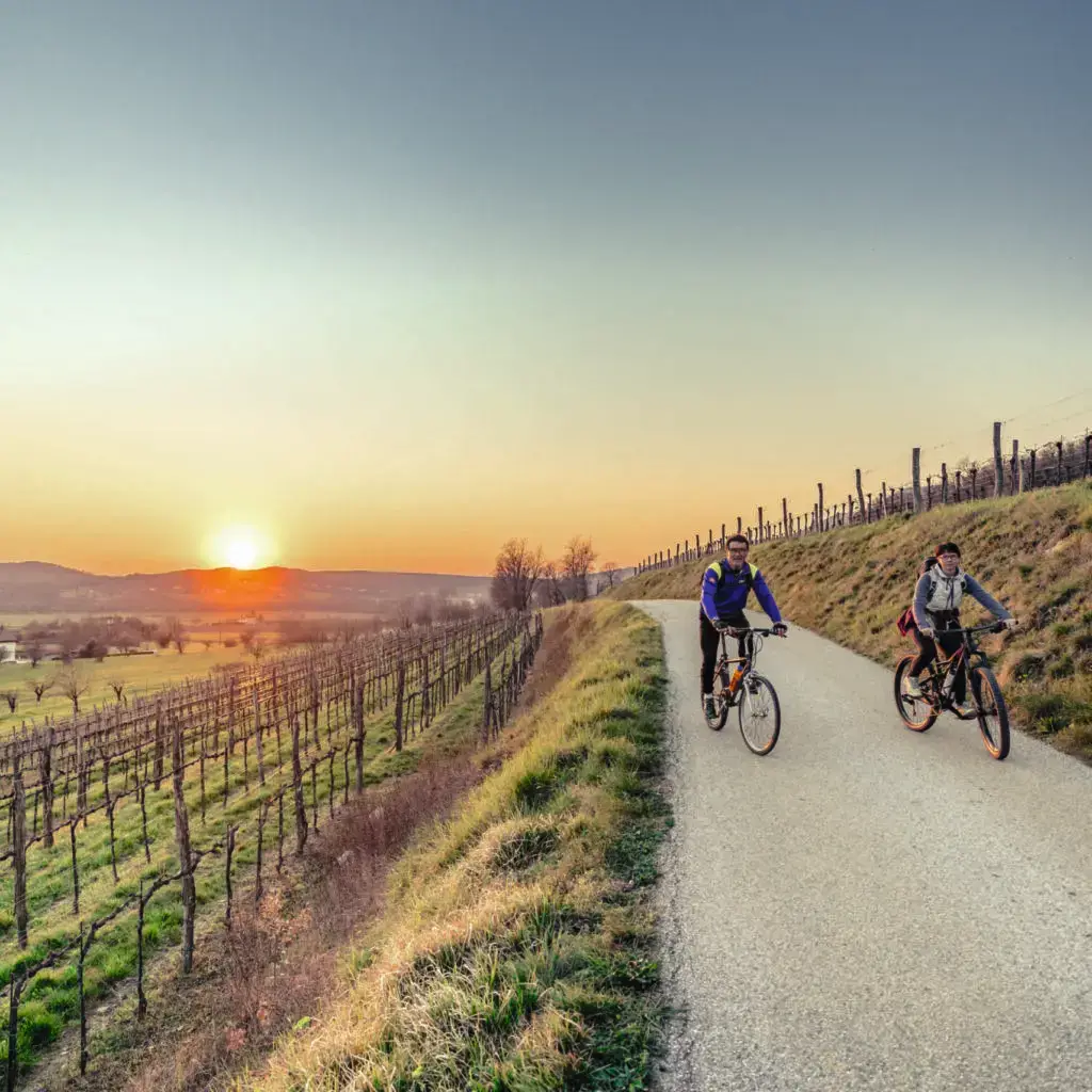 Biker couple riding moutain bike in the countryside at sunset